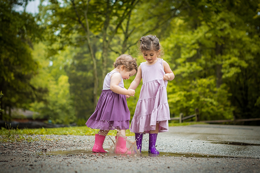 Two little girls playing in a puddle