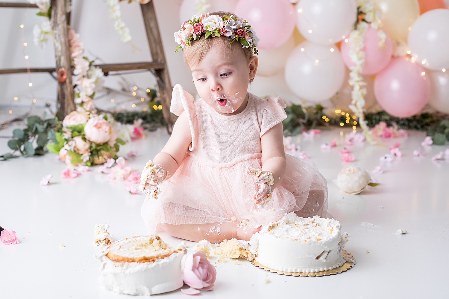baby makes uh ohh face as she knocked cake over