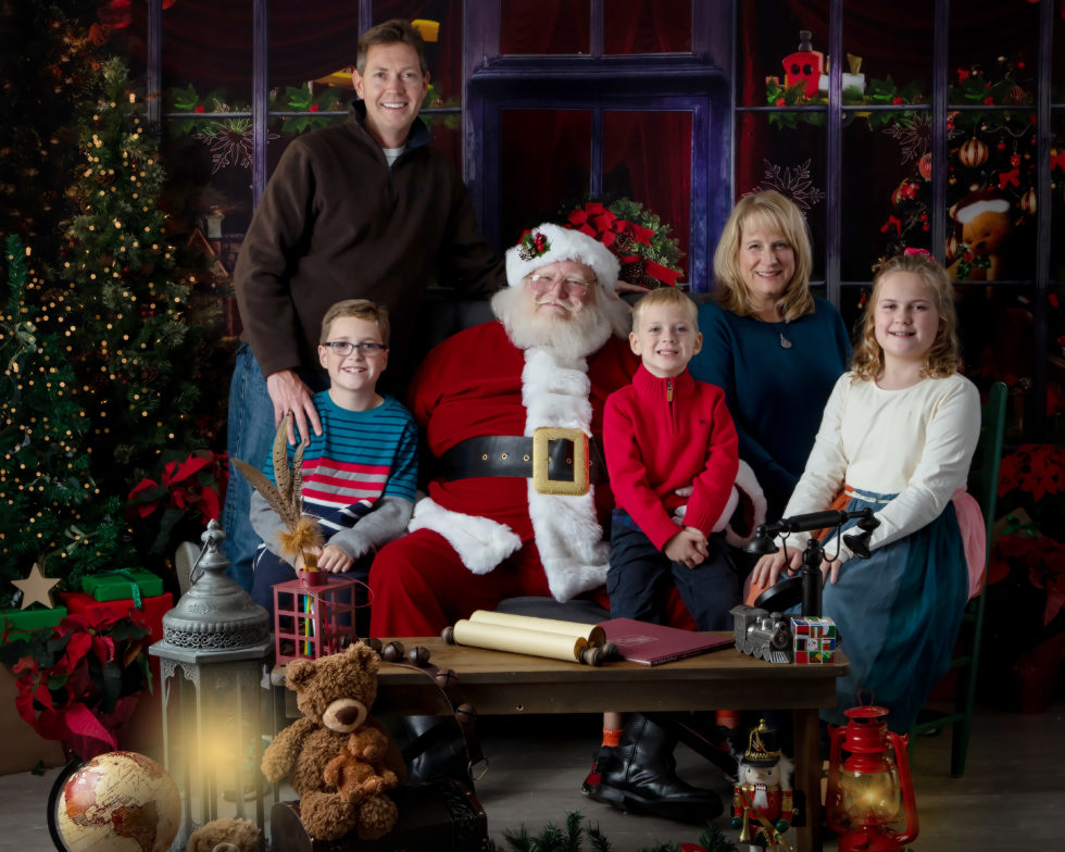 family sits with santa in magical christmas set