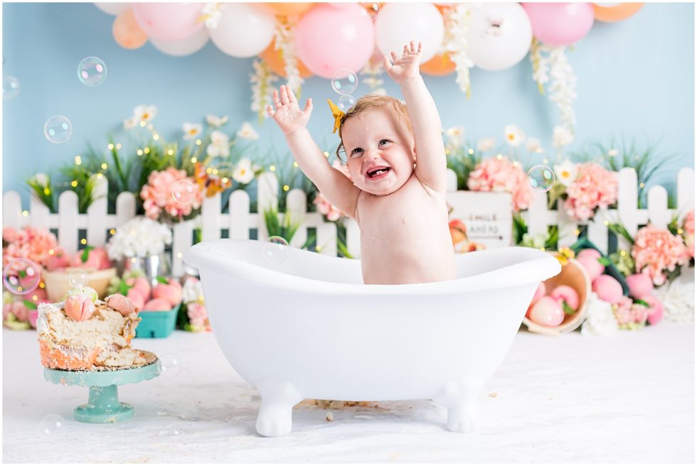 baby gets cleaned up in tub after cake smash session