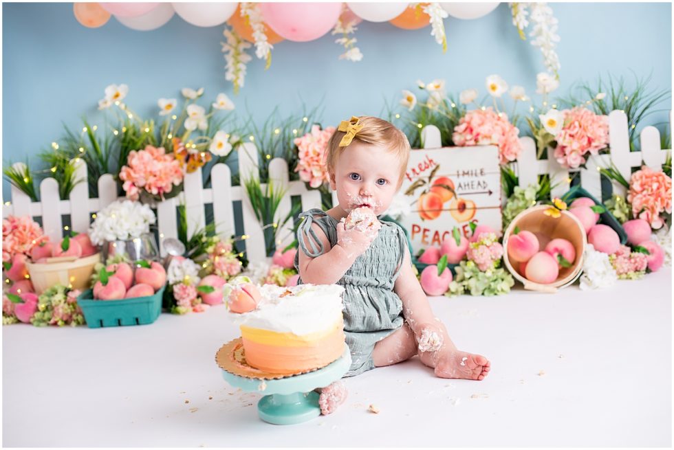 baby girl eats peach themed cake in cincinnati ohio